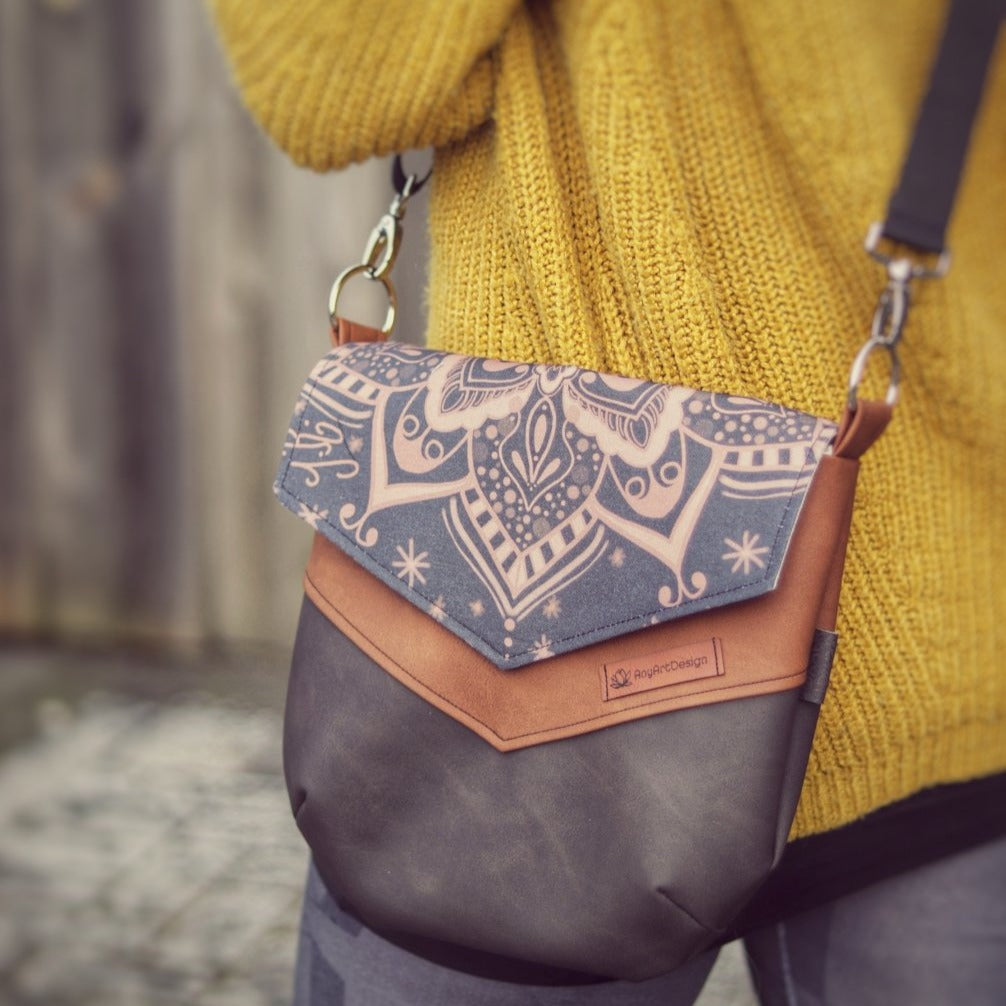 Tragebild einer Handtasche aus dunkel- und Hellbraunem Kunstleder mit dunklem Mandala von AnyArtDesign